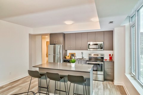 modern kitchen with stainless steel appliances and island with three stools