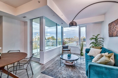 a living room with a blue couch and a view of the city
