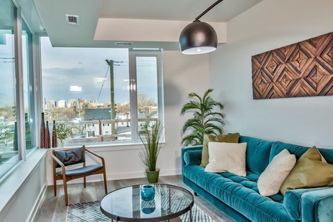 a living room with a blue couch and a large window