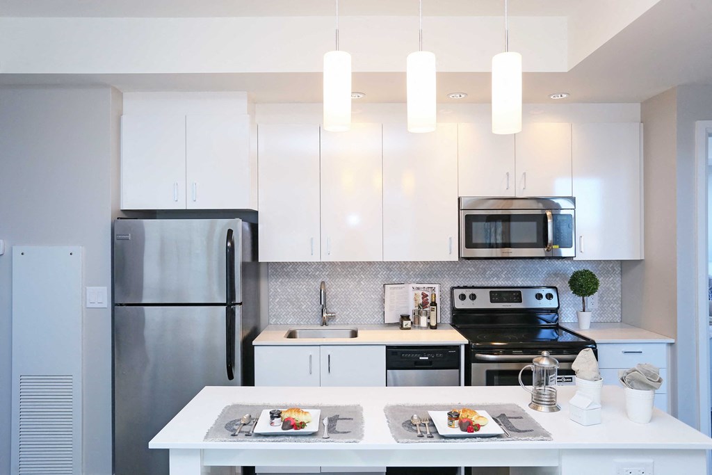 a white kitchen with stainless steel appliances and white cabinets