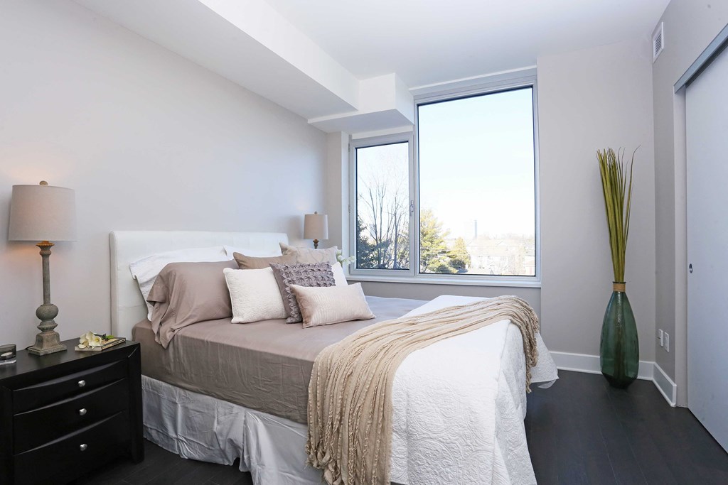 a bedroom with a bed and a large window