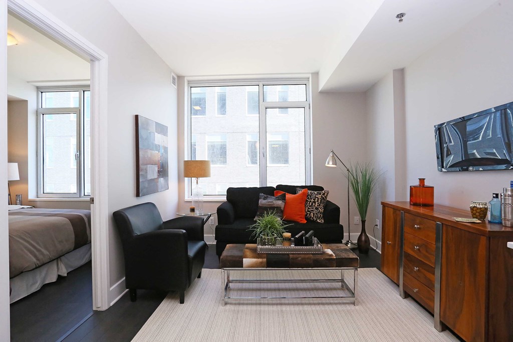 a living room with a couch and a table in front of a window