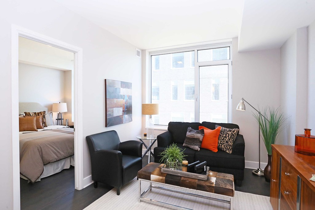 a living room with a couch and a table and a bedroom with a bed