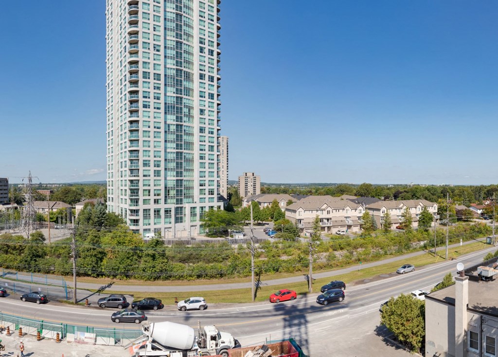 an aerial view of a city with a tall building and a highway