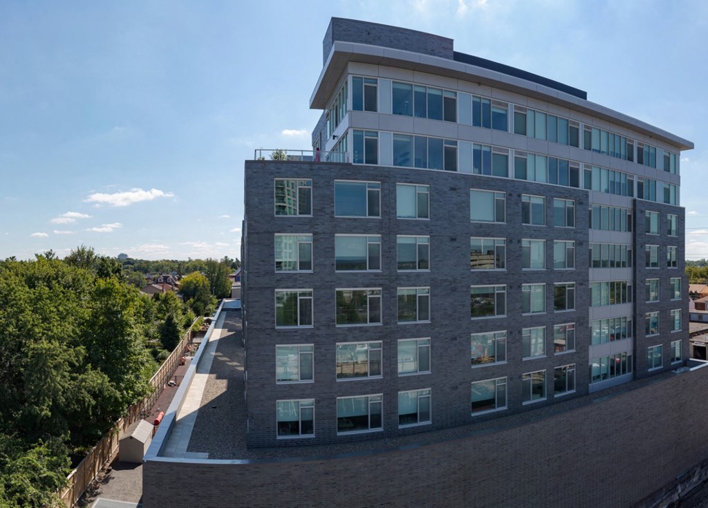 an aerial view of a tall building with trees in the background