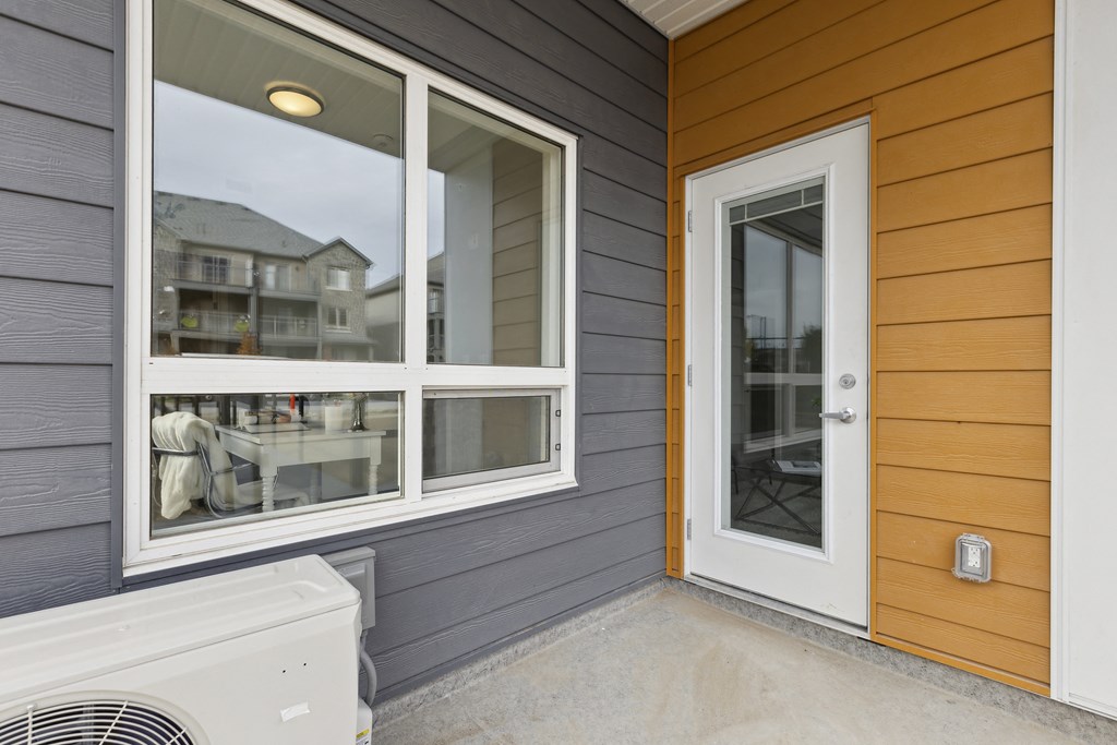 a patio outside of a house with a fan and a window