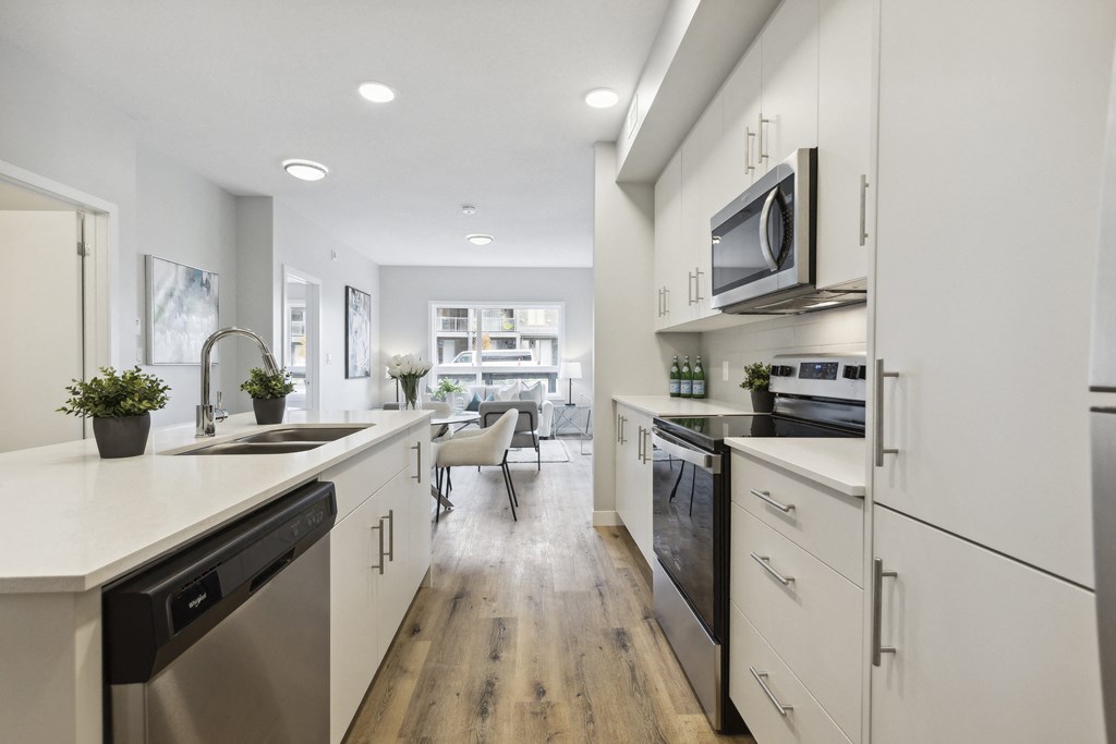 a large kitchen with white cabinets and stainless steel appliances