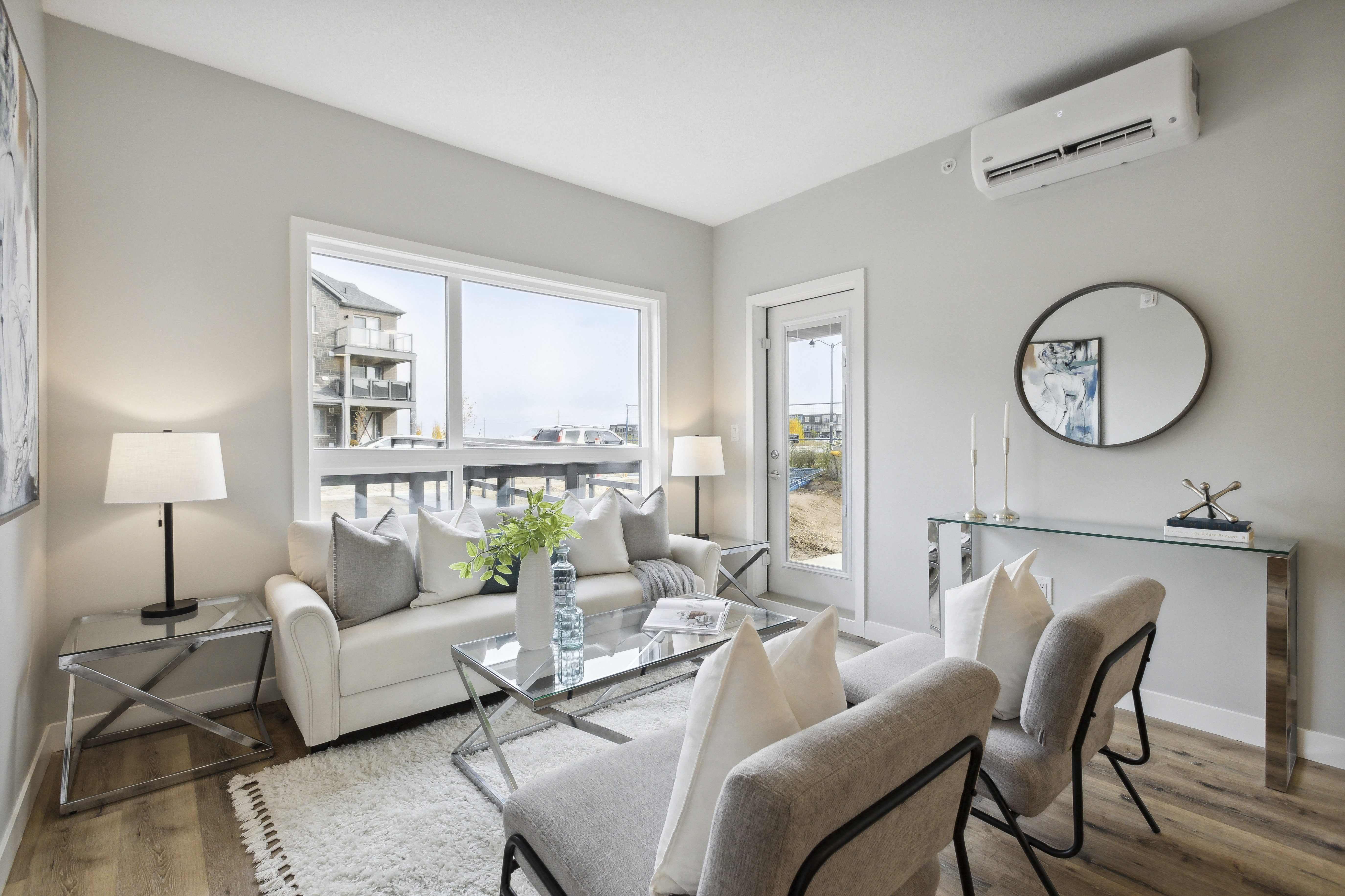 a living room with a white couch and chairs and a glass table