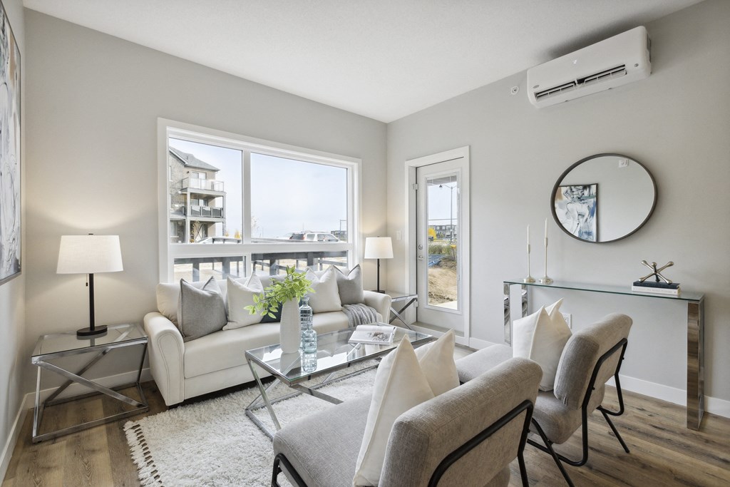 a living room with a white couch and chairs and a glass table