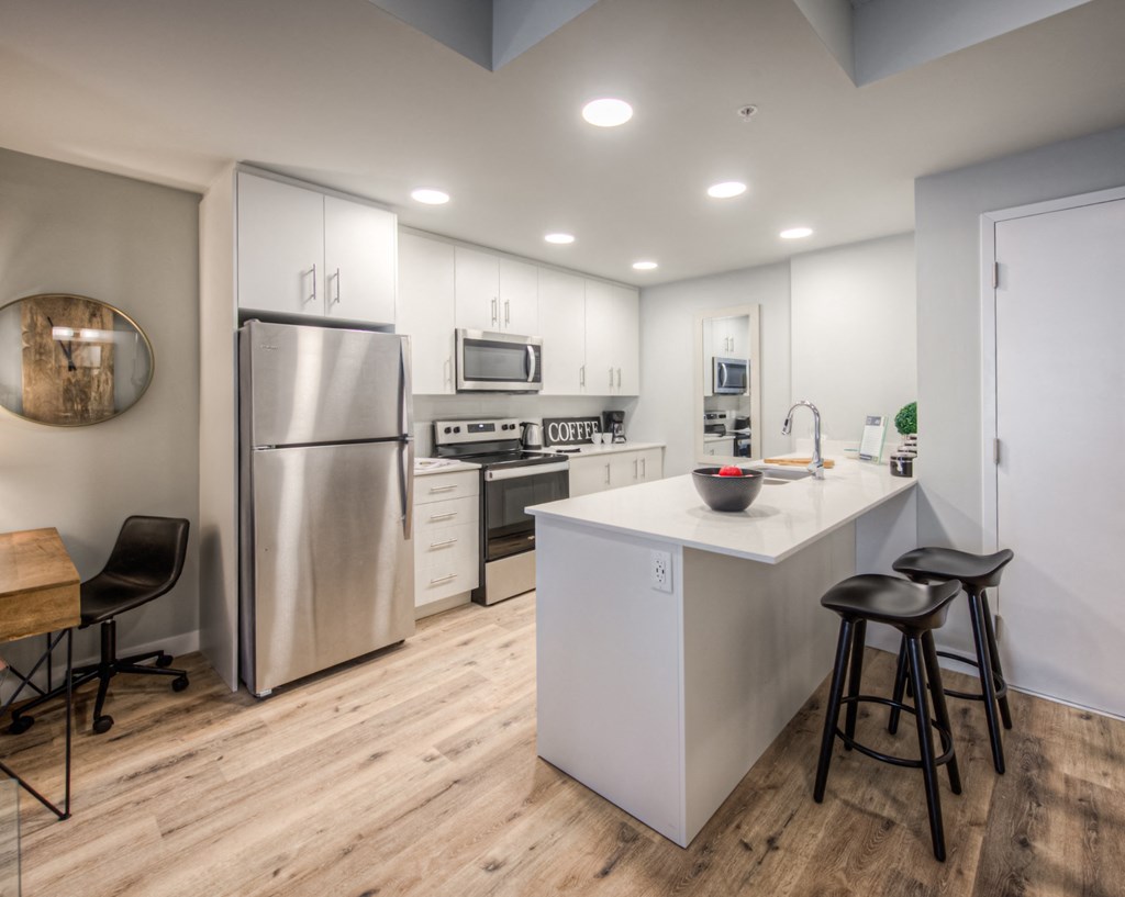 a kitchen with white cabinetry and stainless steel appliances