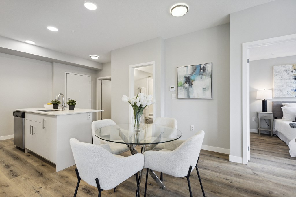 a dining room with white chairs and a glass table