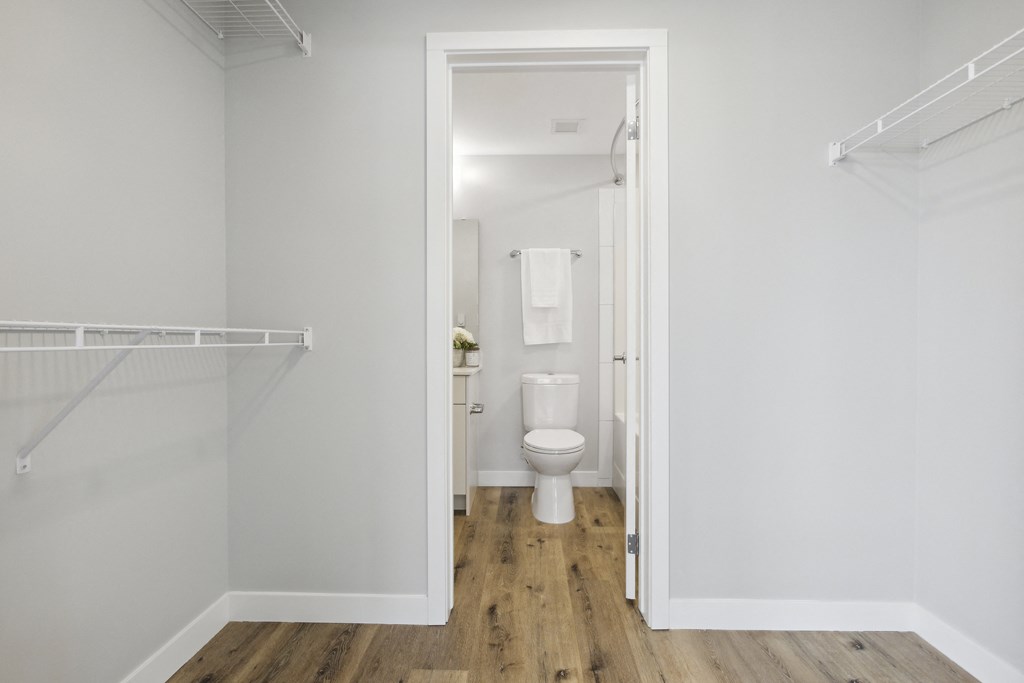a white bathroom with a toilet and a shower