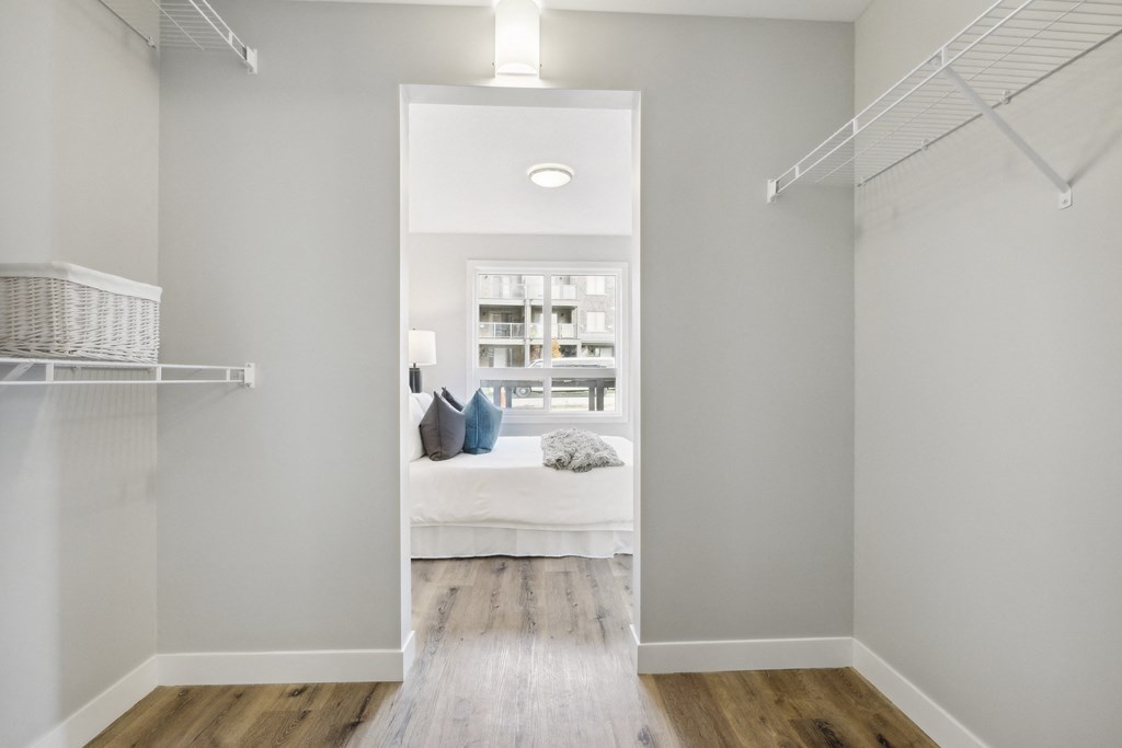 a walk in closet in a bedroom with a bed