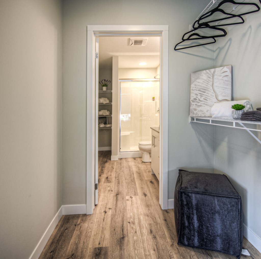 a bedroom with a bed and a stool in a room