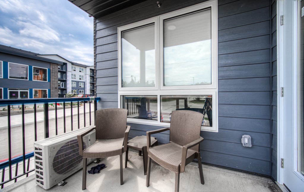a balcony with two chairs and a heater