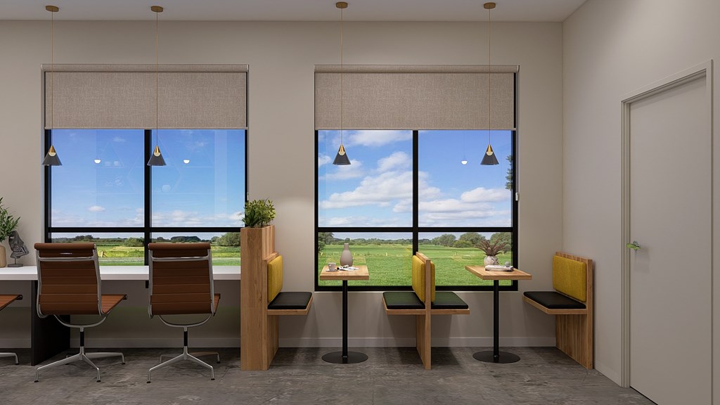 A room with a view of a green field through the windows.