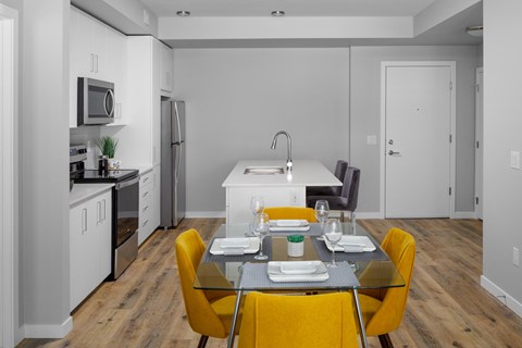 A modern kitchen with a dining table set for two.