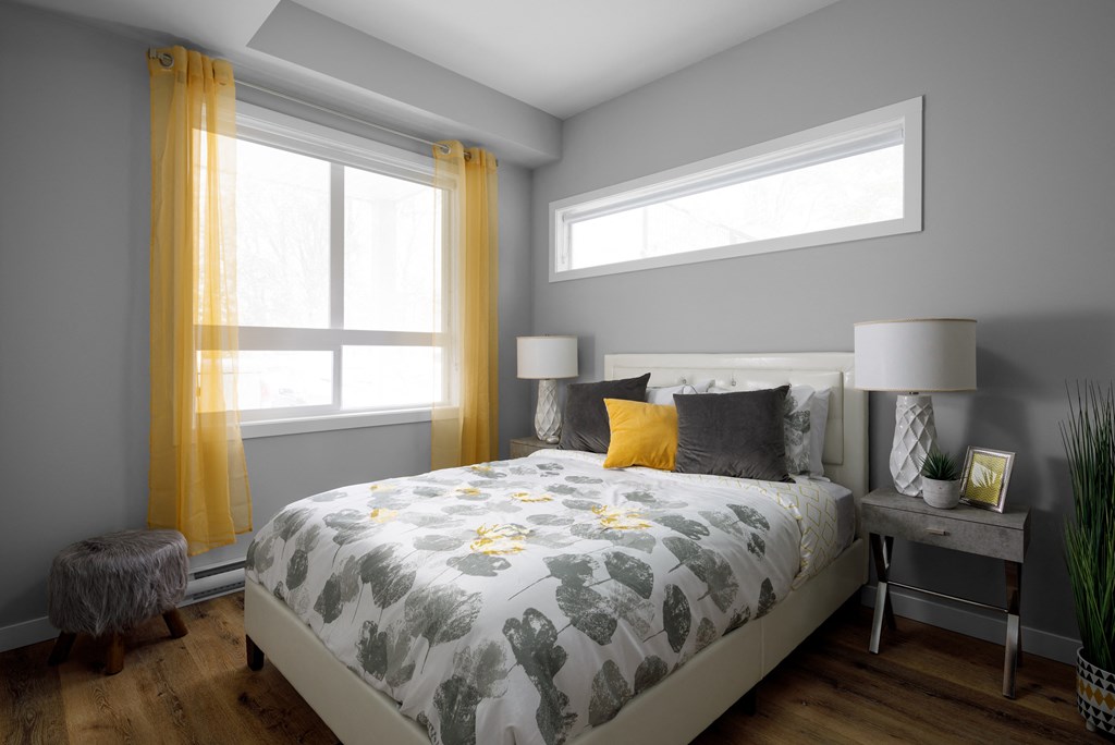 a bedroom with grey walls and yellow curtains