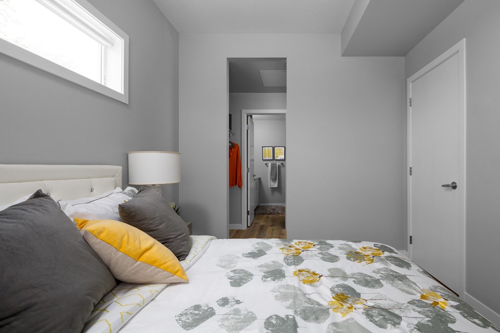 a bedroom with grey walls and a yellow and grey bedspread