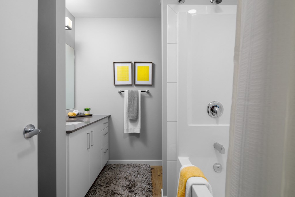 a bathroom with a shower sink and bathtub in a 555 waverly unit