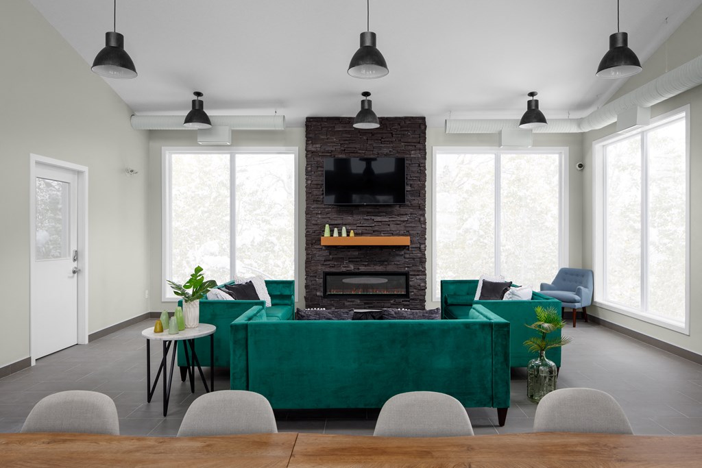 a living room with a green couch and a brick fireplace