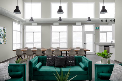 a living room with a green couch and a table with chairs