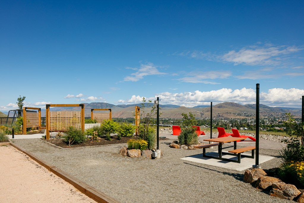 A park with a bench, a fence and a gate.