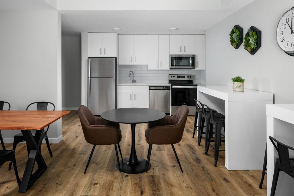 A modern kitchen with a dining table and chairs.