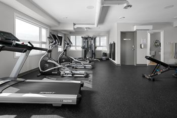 a room filled with cardio equipment and weights