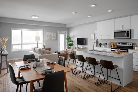 A modern kitchen with a dining table set for four.