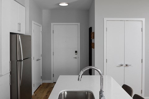 a kitchen with a white counter top and a stainless steel refrigerator