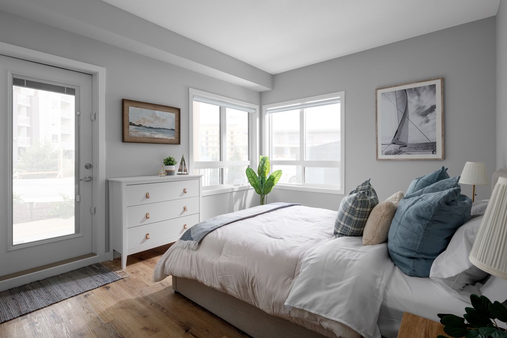 A bedroom with a large bed, a dresser, and a window.