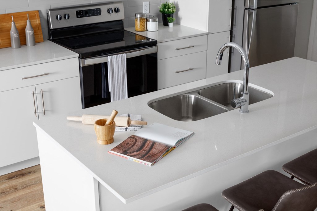 a white kitchen with a sink and a counter top