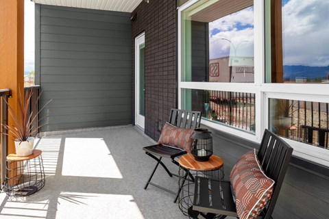 a porch with a table and chairs and a large window