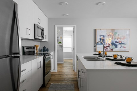 A modern kitchen with white cabinets and a refrigerator.