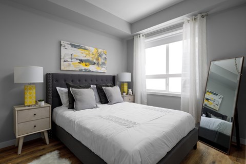 a bedroom with gray walls and a white bed