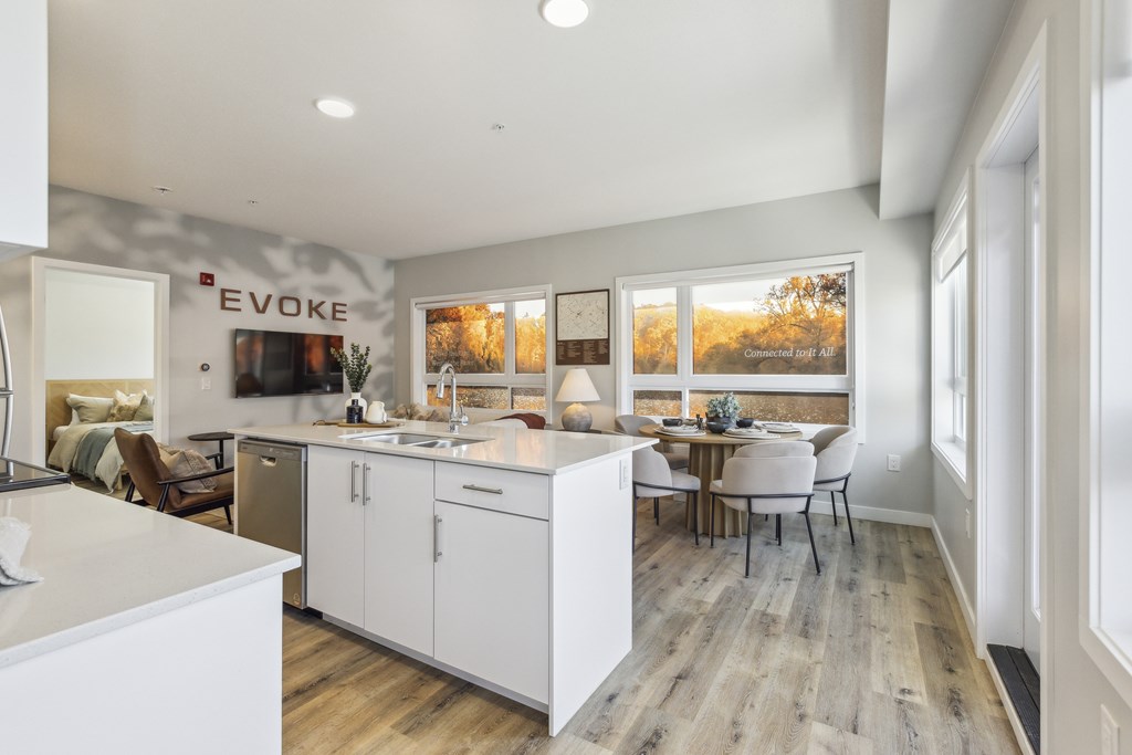 A kitchen with white cabinets and a dining table with chairs.