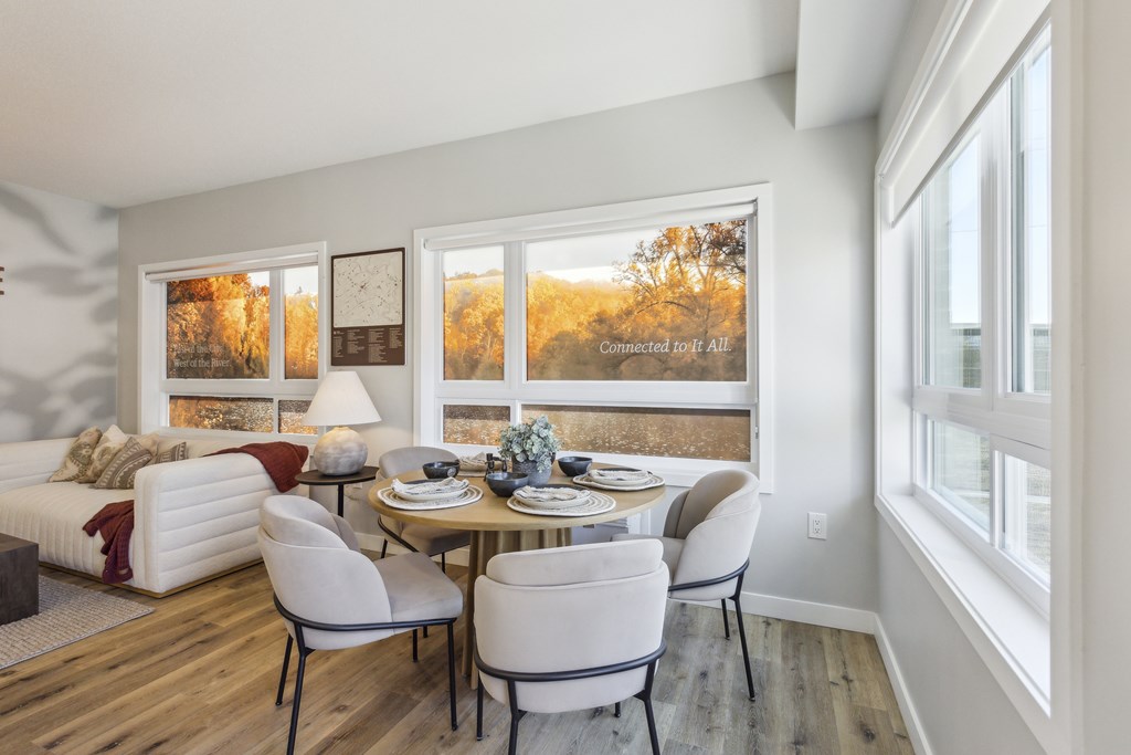 A dining room with a white couch and a table set for two.