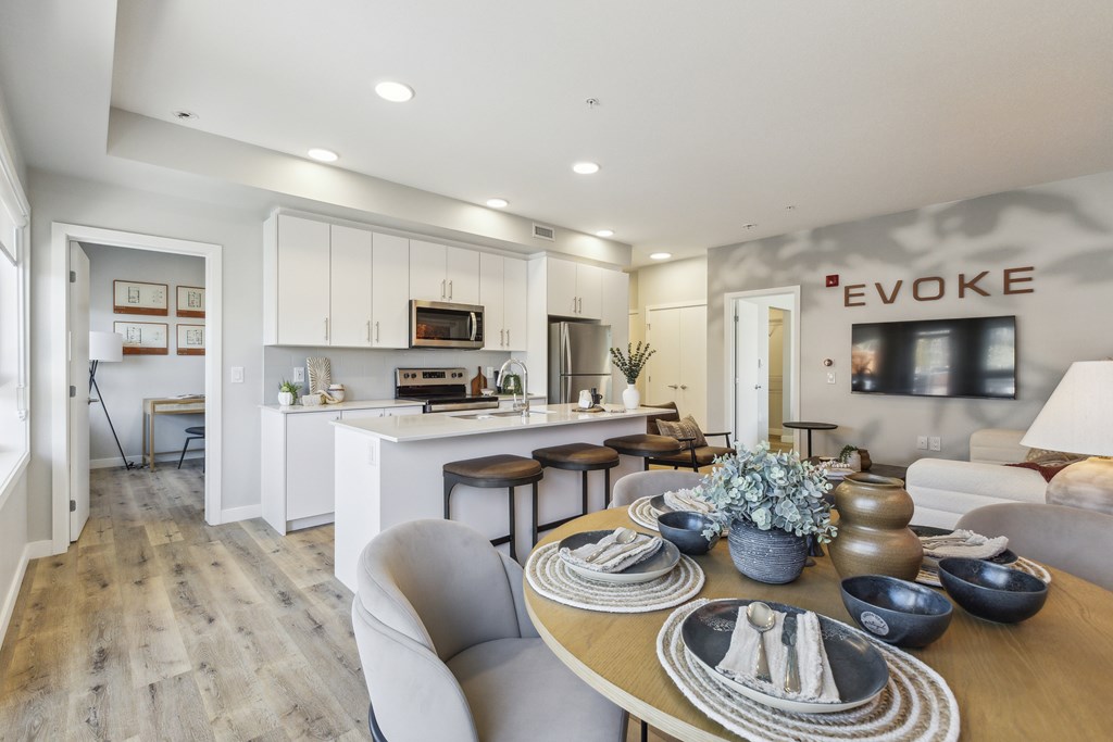 A modern dining room with a wooden table set for a meal.