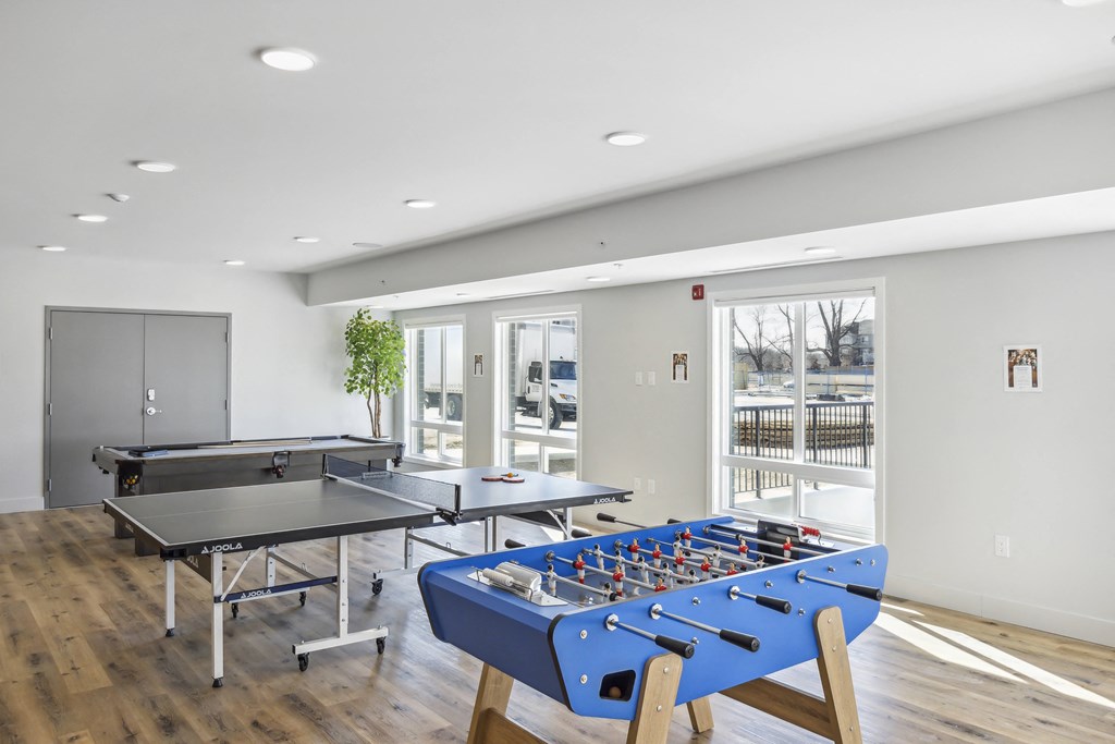 a games room with tables and ping pong