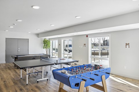 a games room with tables and ping pong