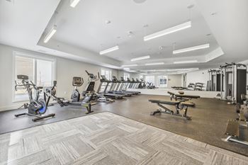 a gym with cardio equipment and weights on the floor