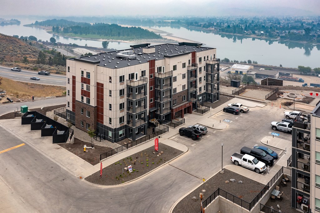an aerial view of an apartment building with a river in the background