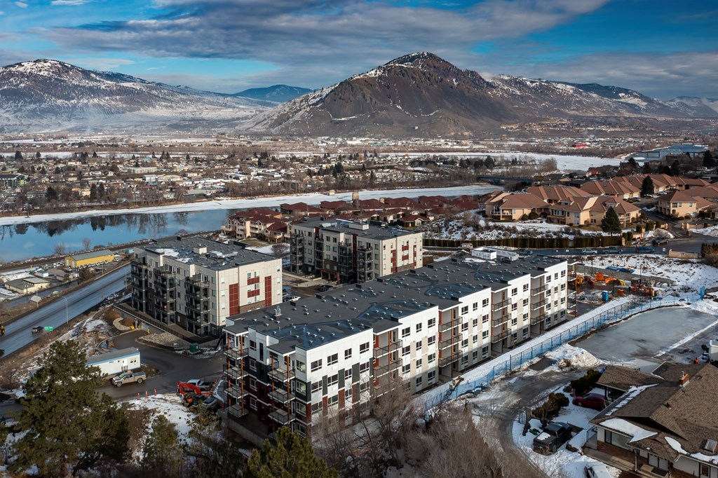 a cityscape with a river and mountains in the background