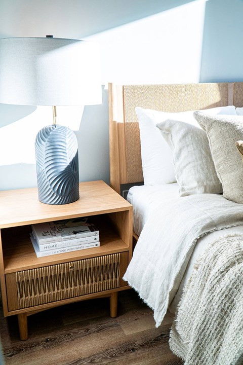 A bedroom with a bed, nightstand, and lamp.