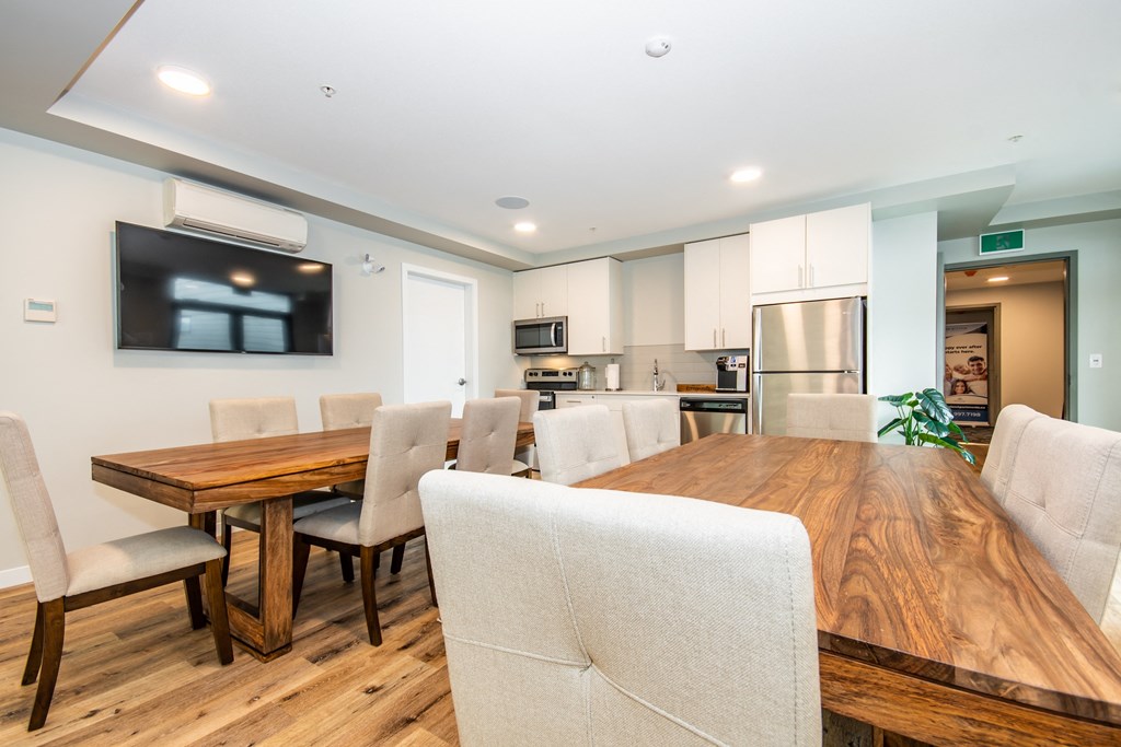 a dining room with a long wooden table and white chairs
