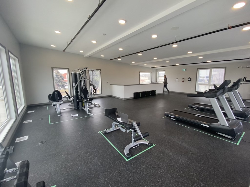 a large fitness room with treadmills and other exercise equipment