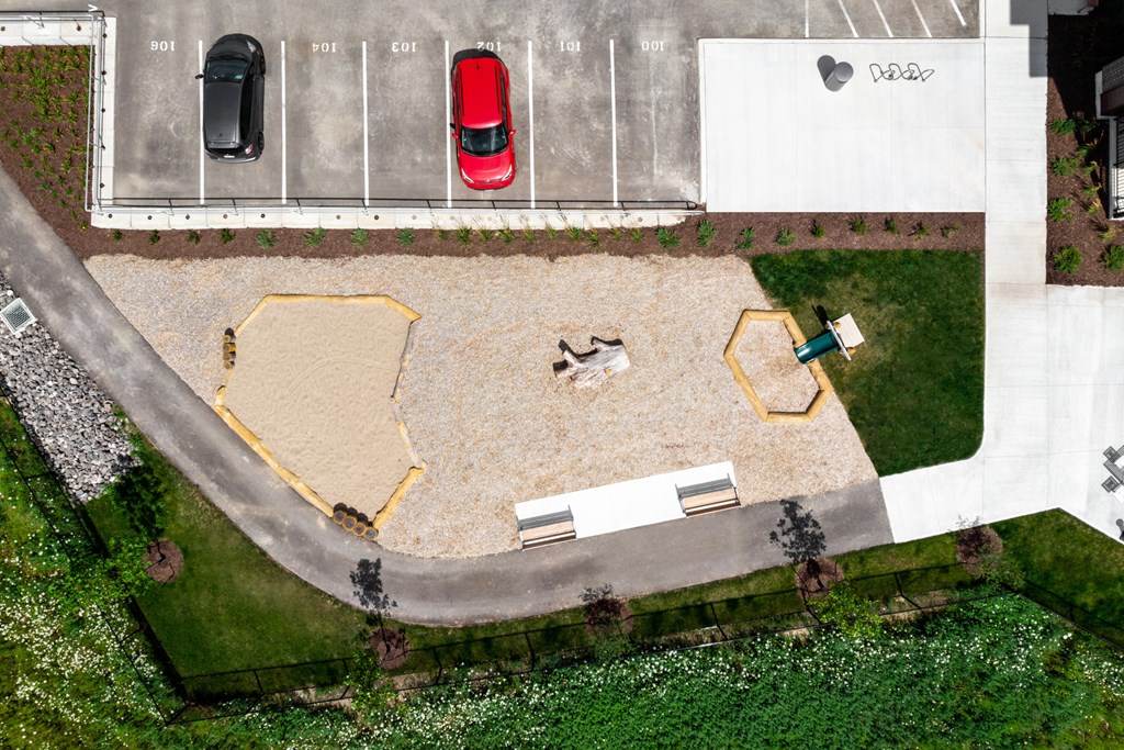 a drone shot of a parking lot with a bench and a bench in the middle of the