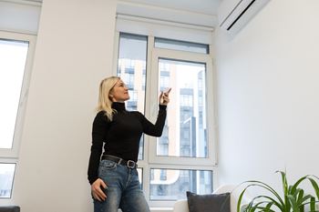 a woman standing in front of a window pointing at something