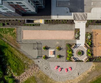 a bird's eye view of a courtyard with plants and a parking lot